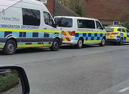 Two immigration vans and a police car were pictured in Station Road earlier today.