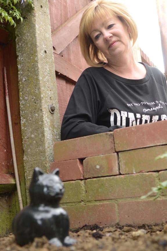 Karen Jones next to the grave of the black cat who she thought was her own