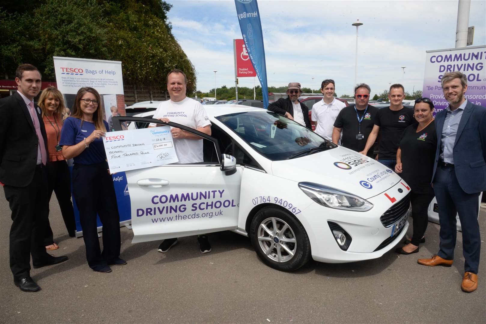 Loisa Dane, Community Champion at Tesco presents John Nicholson with a new car and a cheque for £4000