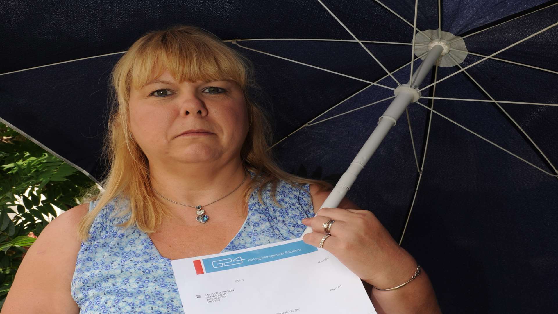 Cathy with her parasol and letter from the parking company
