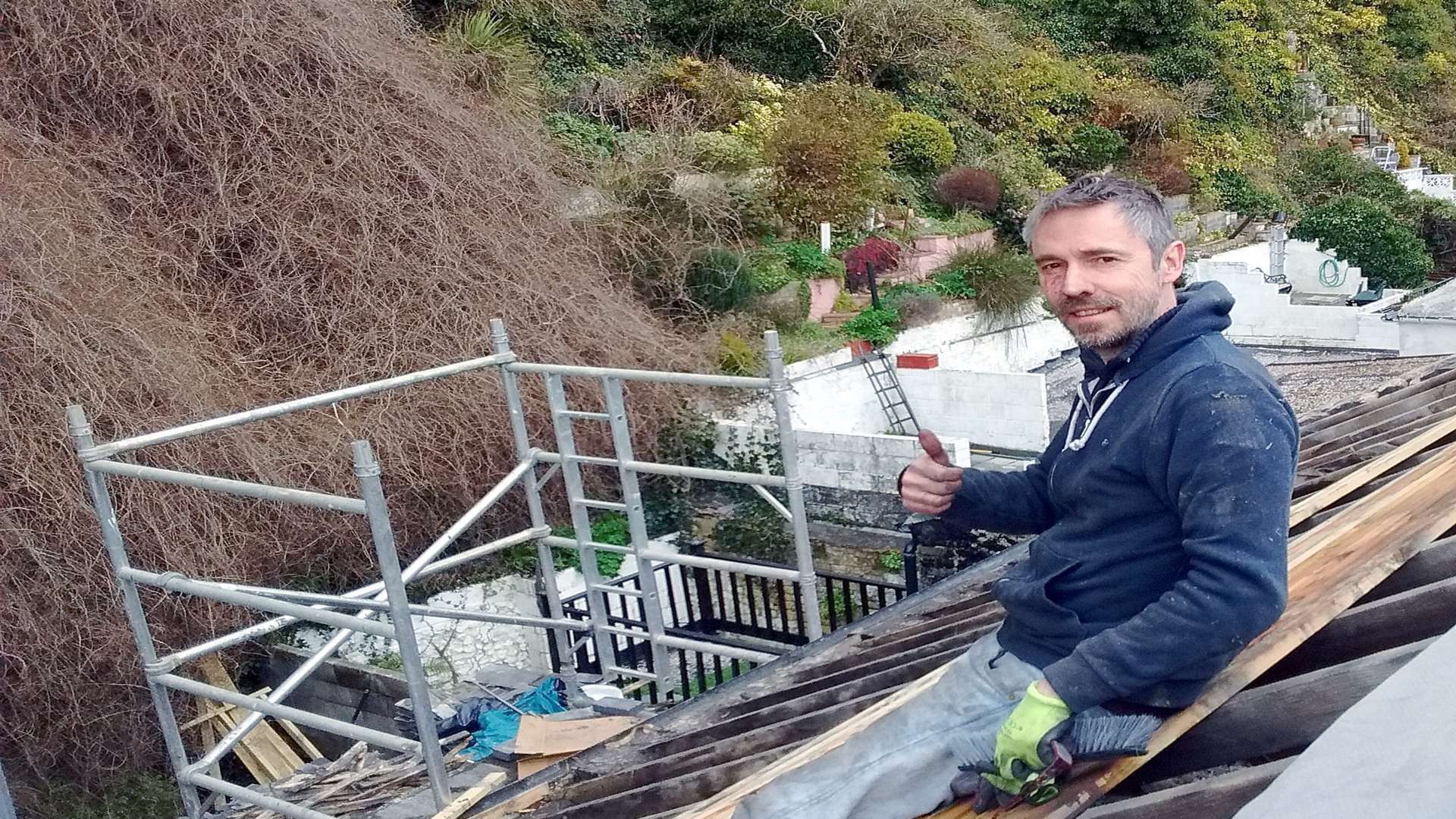 Paul McMullan on the roof of his damaged new pub