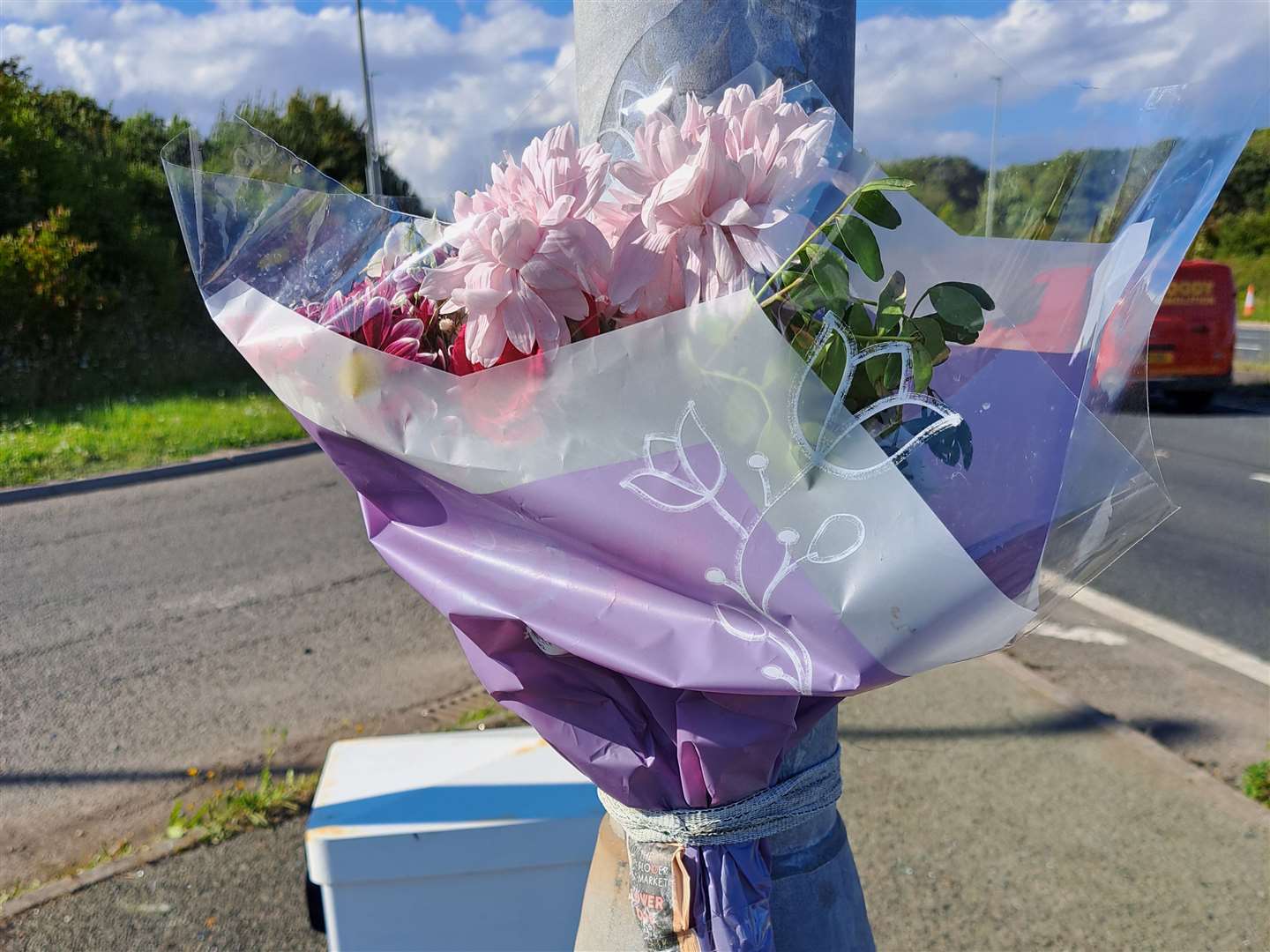 A single bunch of flowers have been tied to a lampost in tribute