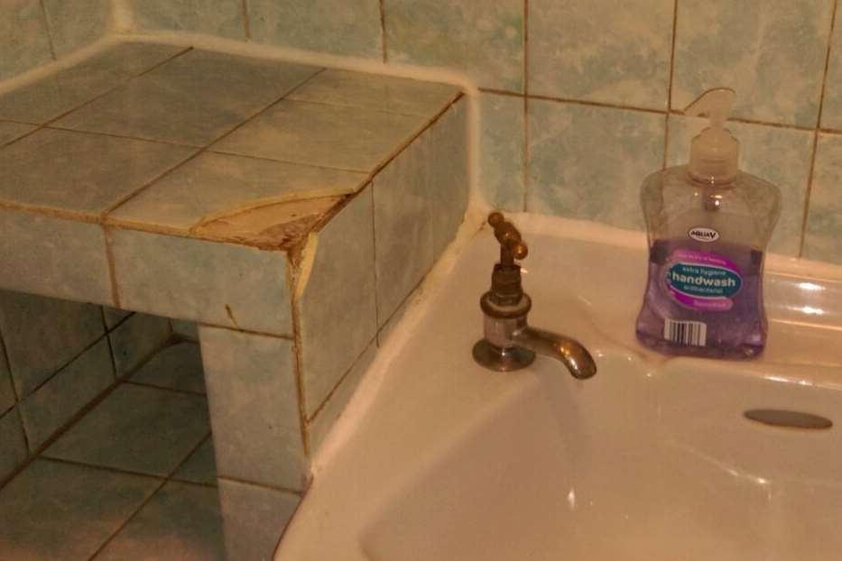The bathroom had broken tiles.