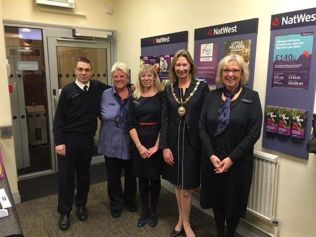 Former New Romney Mayor Patricia Rolfe becomes the last ever customer of the town's NatWest bank on its closing day. She is pictured with staff. Credit: Patricia Rolfe
