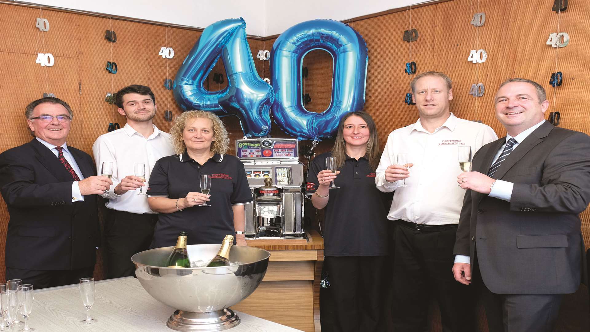 Ivor Thomas, left, with Paul Thomas, right, and some of the team celebrating 40 years