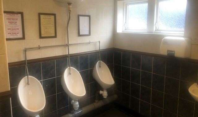 Each of the three urinals had a frame for reading material, but the one on the left featured previous events and the one on the right was empty