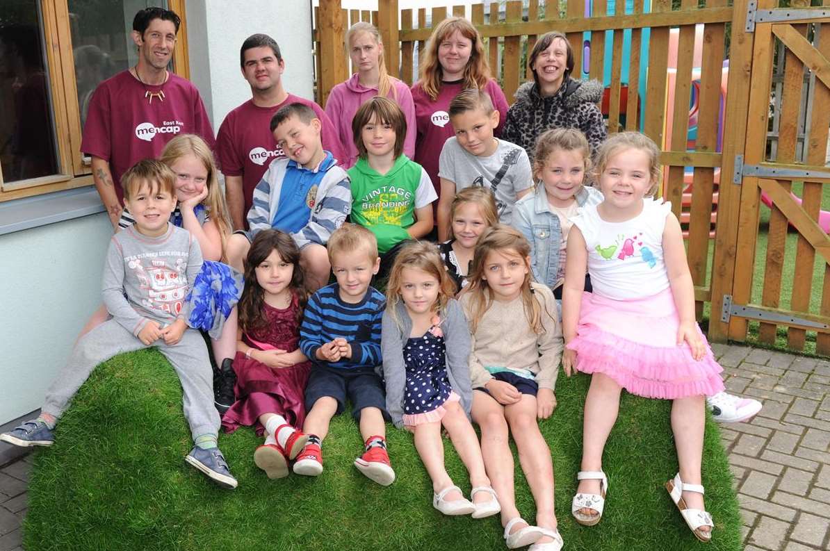 Children on the holiday playscheme with the Mencap members sitting on a grass sofa