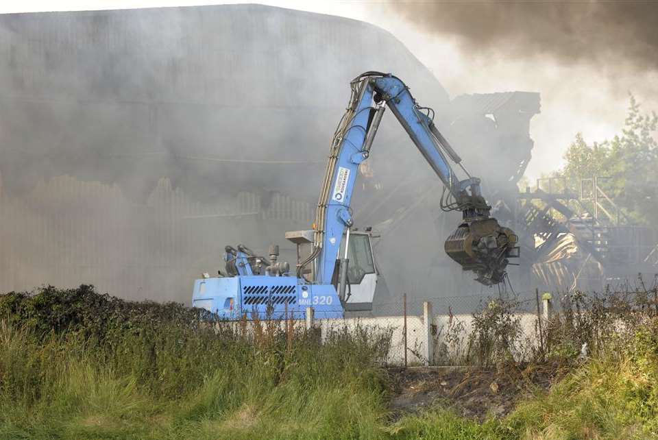 A mechanical loader is used to move material away from the fire. Picture: Andy Payton