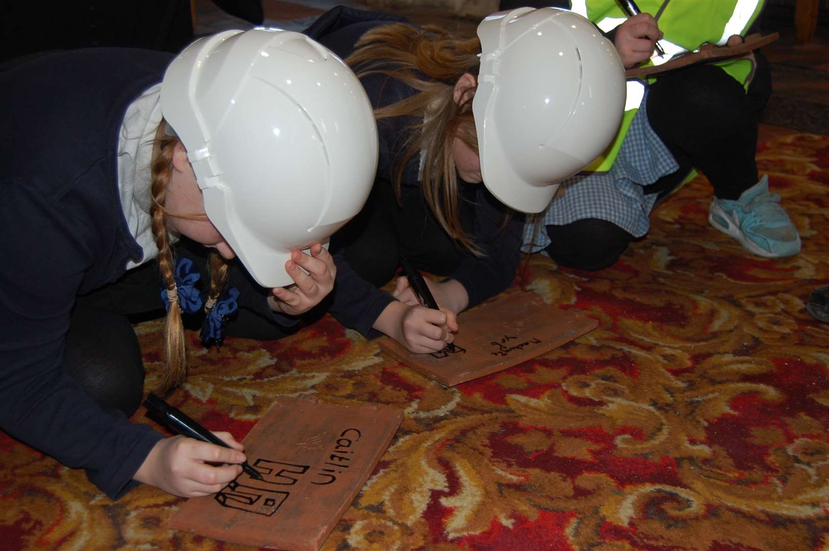 Pupils from Lawn Primary School each sign a tile for the church's new roof.
