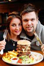 KMFM breakfast presenters take on the challenge. Rob and Emma with the giant burger