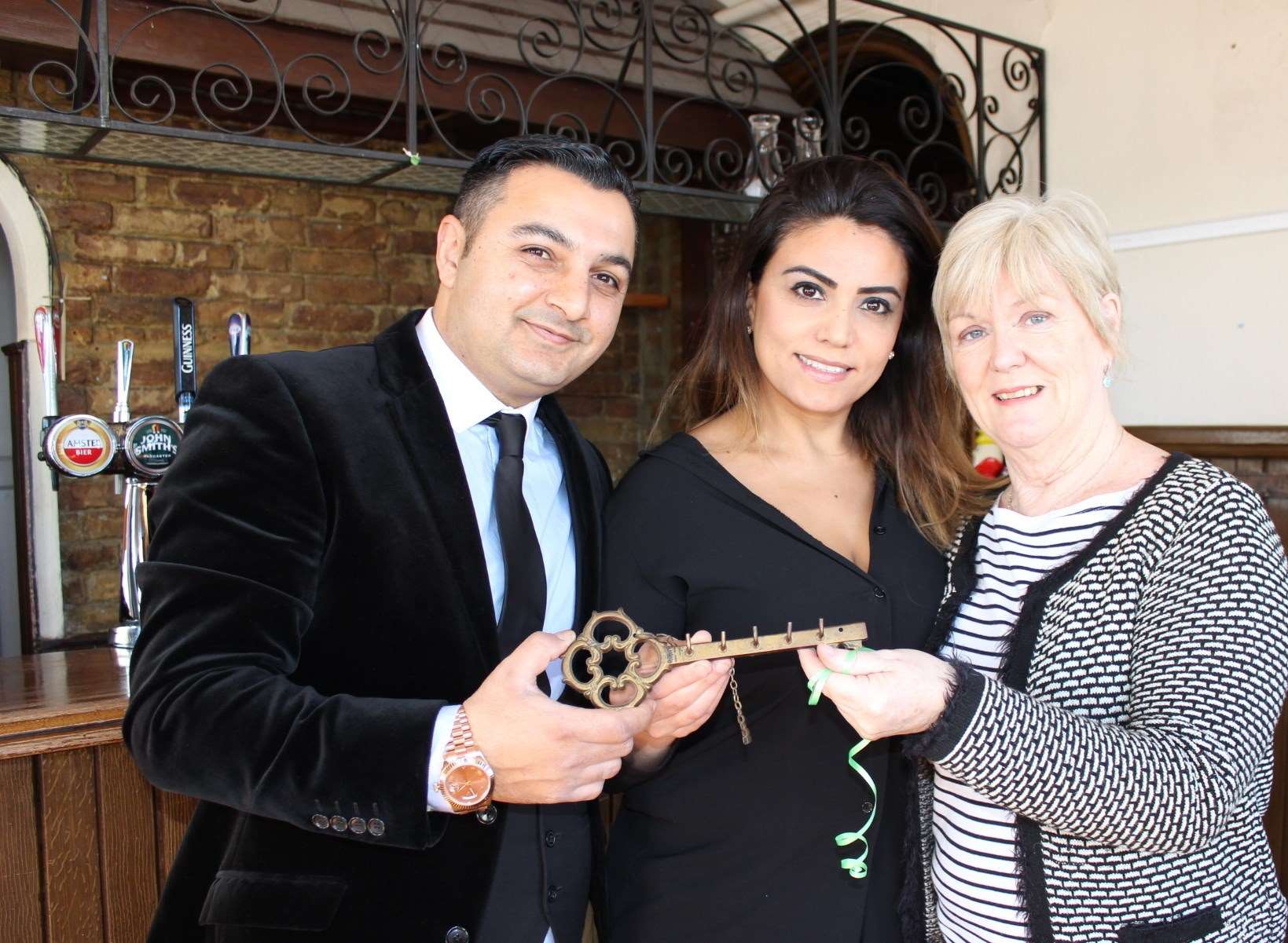 Trudie Gannon, right, hands over the "key of the the door" of the Halfway House to Mehmet and Elvin Suzgun who are going to turn the former pub into a Turkish restaurant