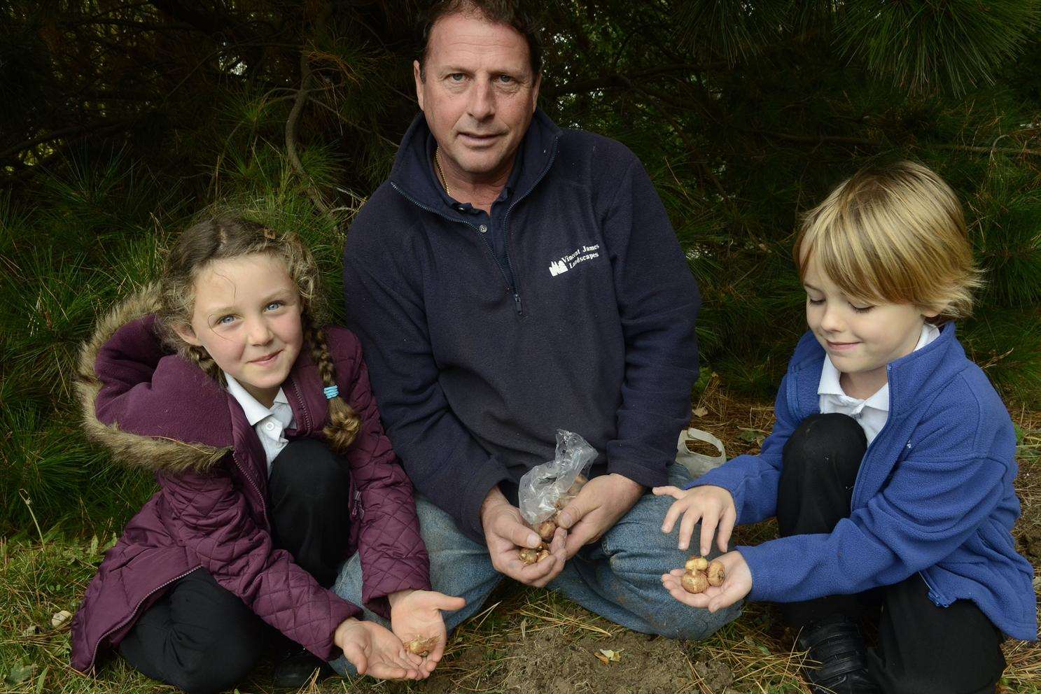 Leah Redsell and Cameron Mepstead, both five planting bulbs with Steve Merton of Vincent James Nurseries