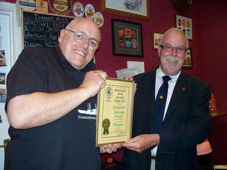 Conqueror landlord Colin Aris accepts the East Kent CAMRA Pub of the Year award from East Kent Area Organiser Jeff Waller.