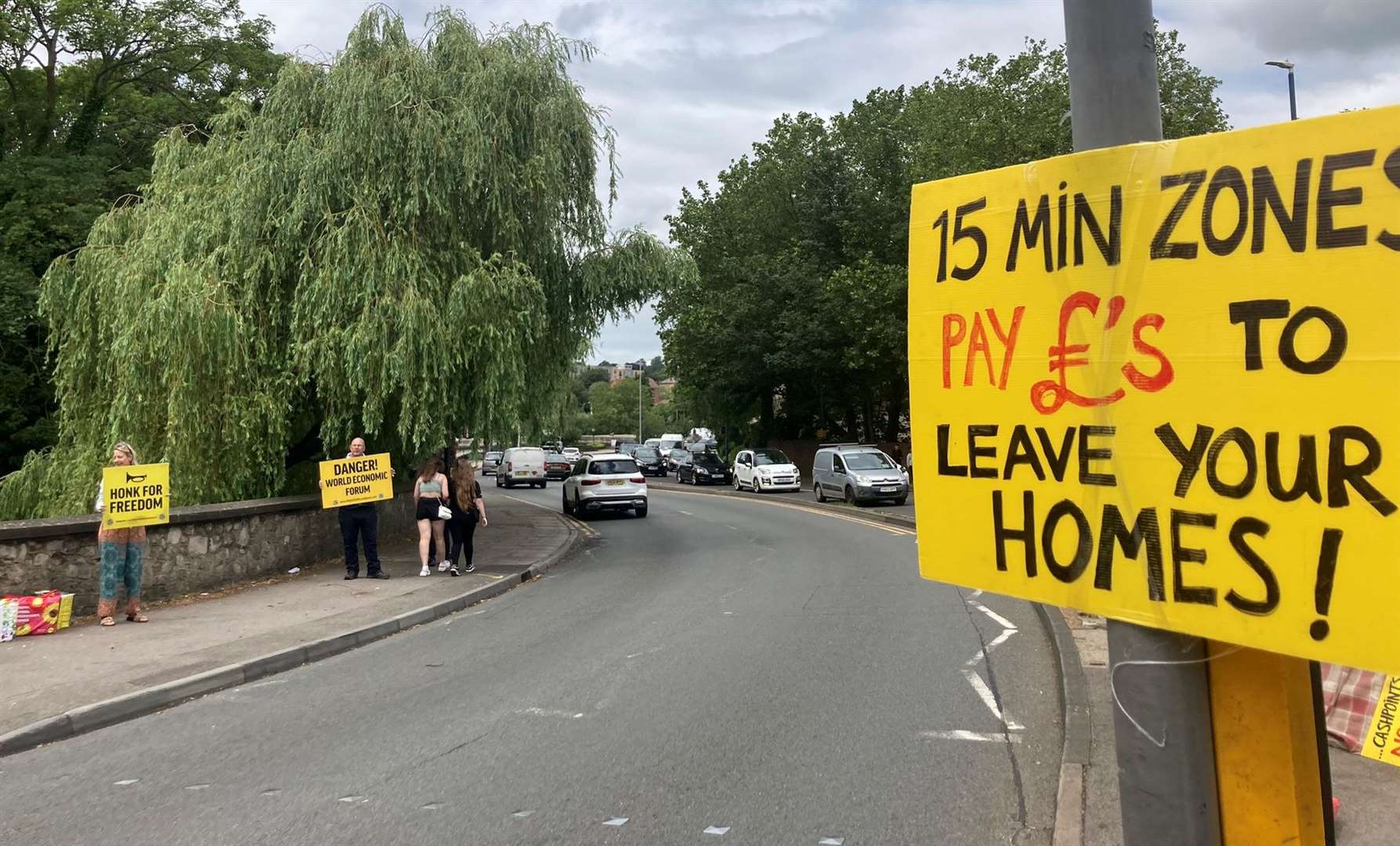 Rebels on Roundabouts wave their yellow boards during a protest in Maidstone