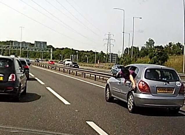 A passenger leans out of the car to fiddle with the petrol cap. Picture: Geoff Watkins