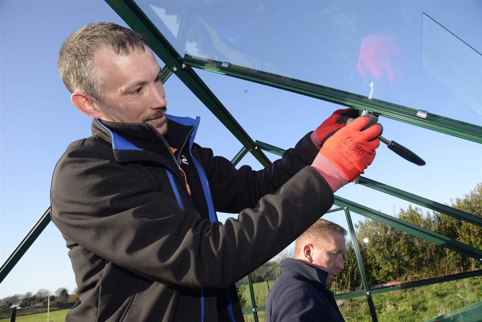Sky engineer Vince Gibbs tightens a bolt whilst helping to erect a greenhouse on the Bright Sparks Nursery allotment in Church Lane, Deal.