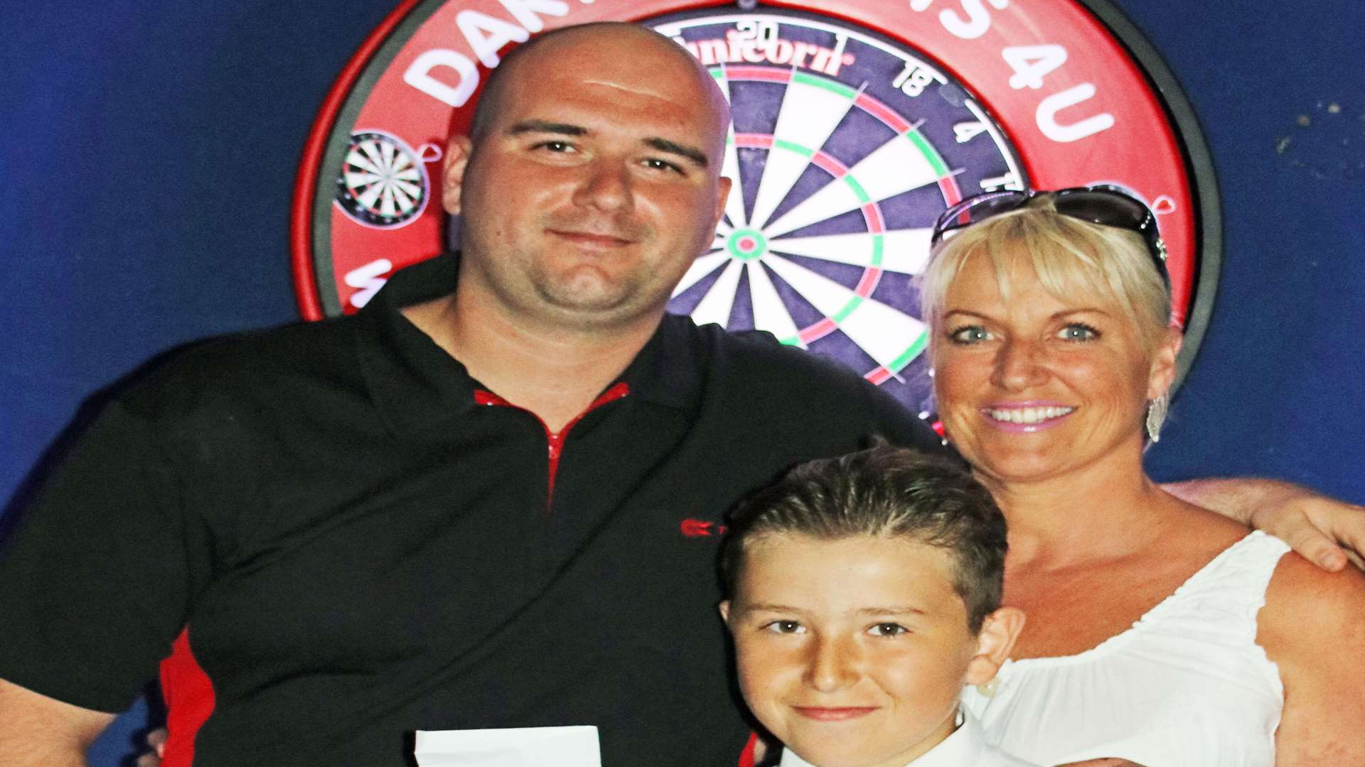 Rob Cross, left, pictured with Merlins Entertainment's Lee Dunn and her nephew Gary after winning the Sheppey Darts Classic in June Picture: Tony Cox