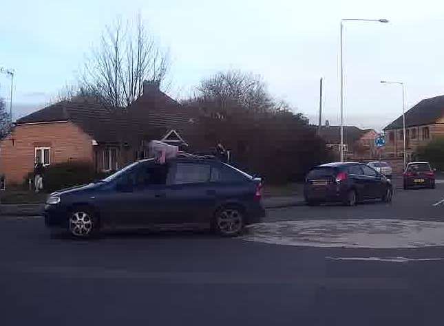 A man was spotted 'surfing' on top of the moving car. Picture: Billy Dempsey.