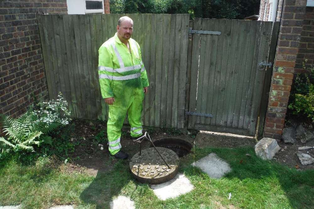 A Southern Water engineer by the manhole in Hasteds where the village's sewage is pumped out from
