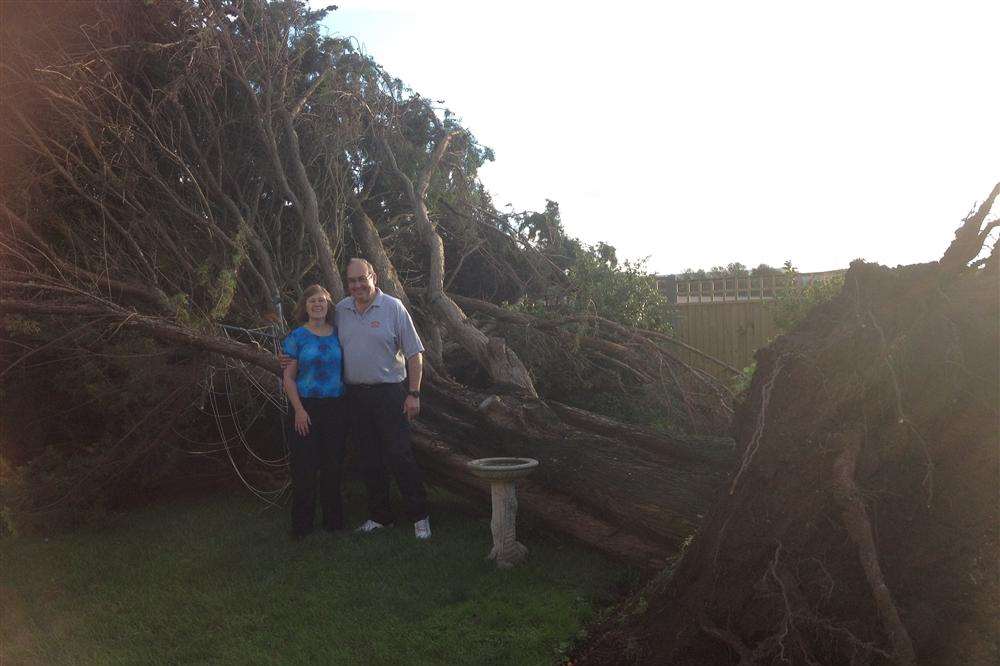 Lucky escape - Tony and Carol Webb with the 60ft fir that smashed down in their garden in the storms at Minster, Thanet