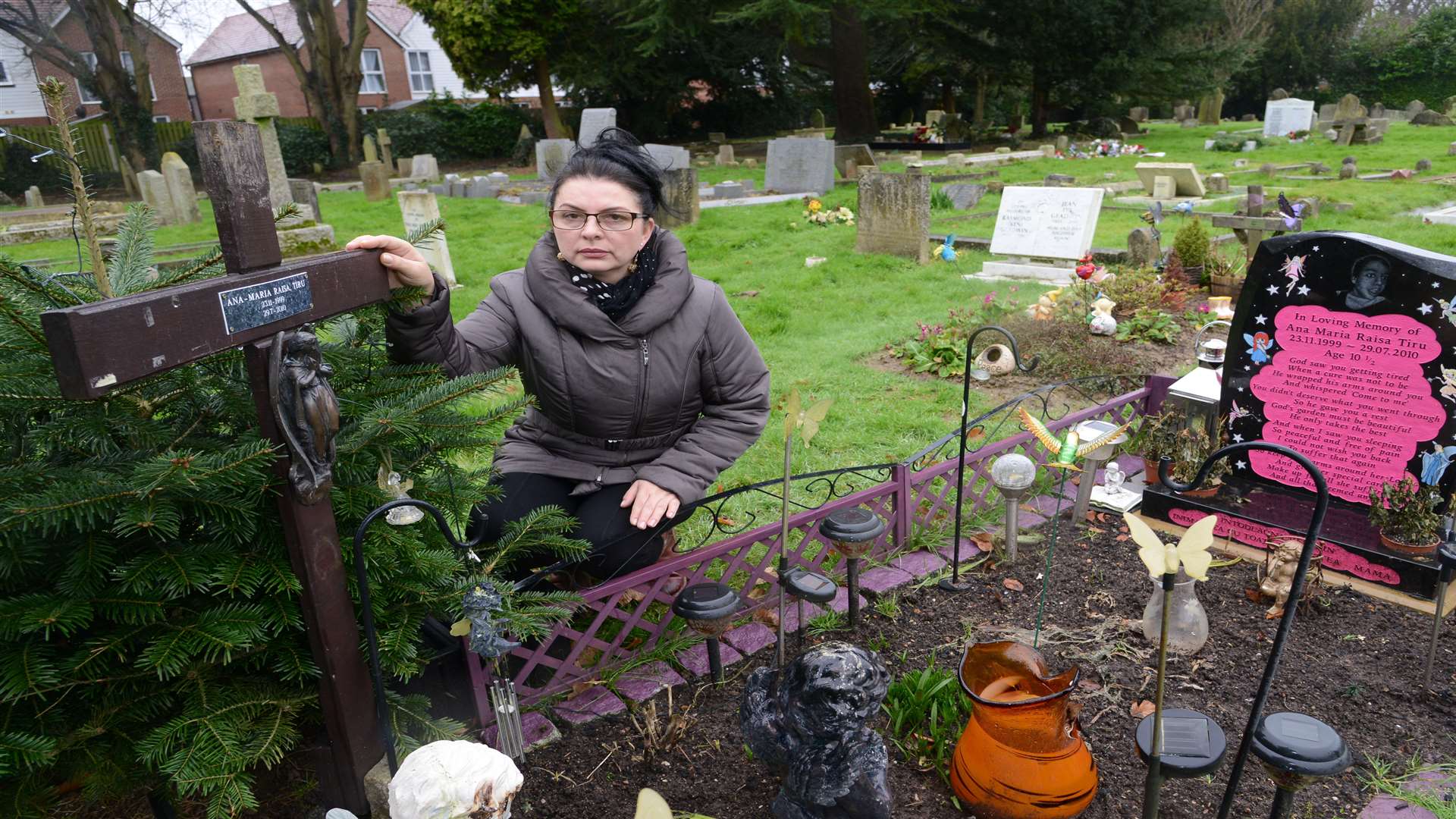 Florica Tiru at her daughter's grave with the cross back in place
