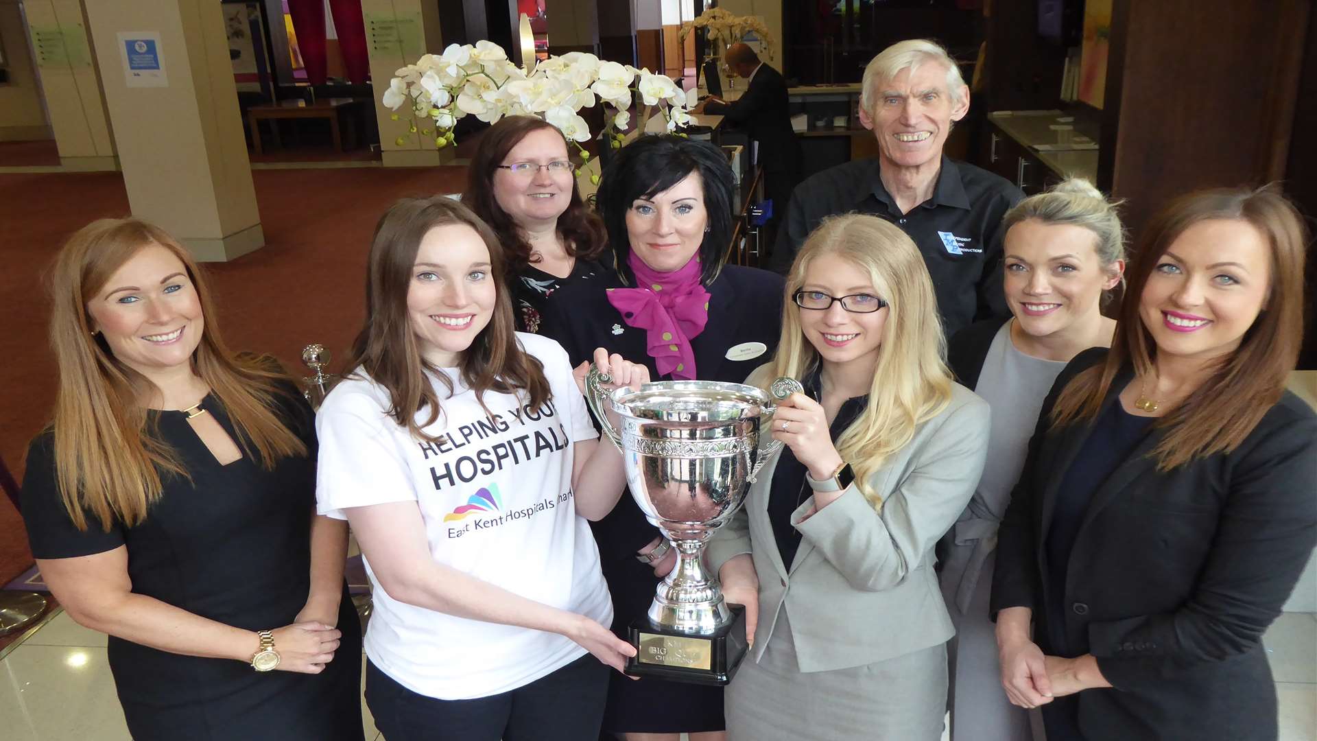 Victoria Adley of East Kent Hospitals Charity Dementia Appeal and Sophie Richardson of Hallett & Co join event partners to unveil the giant trophy teams will be competing for at the KM Big Charity Quiz.