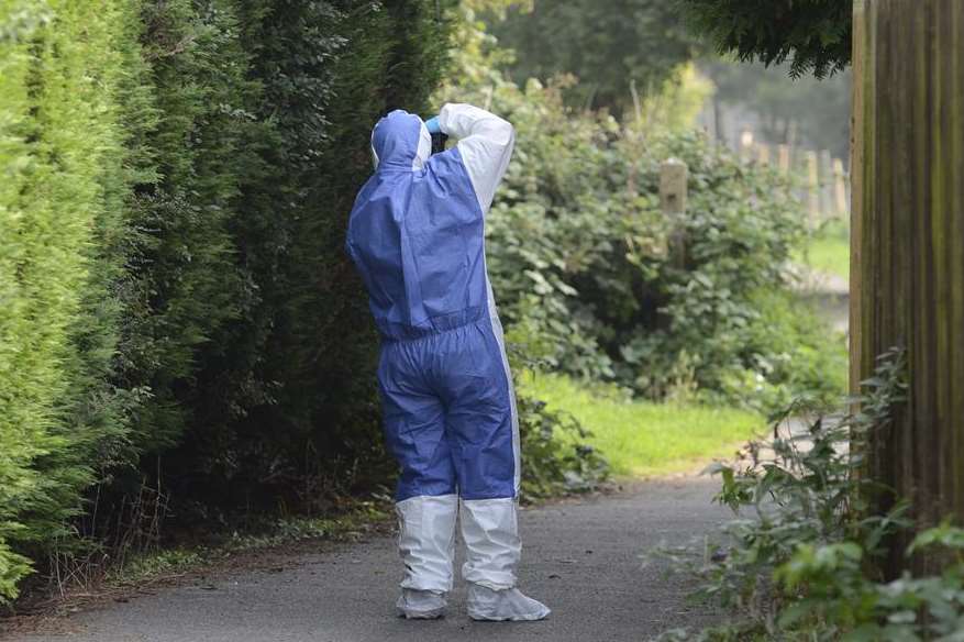 A forensic officer photographs evidence after claims of the sex attack in Willesborough. Picture: Gary Browne