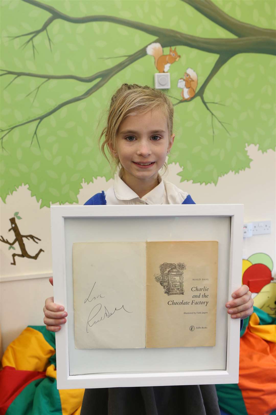 Daisy, nine holds up a signed copy of Charlie and The Chocolate Factory, by Roald Dahl
