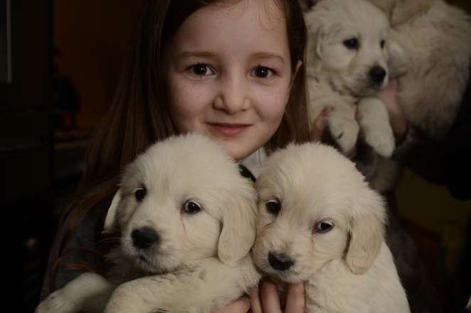 Isis Kennedy cuddles up to two of the puppies