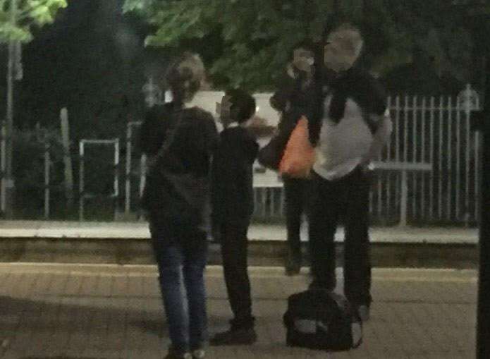 The teenagers near the tracks on the platform at Sandwich station