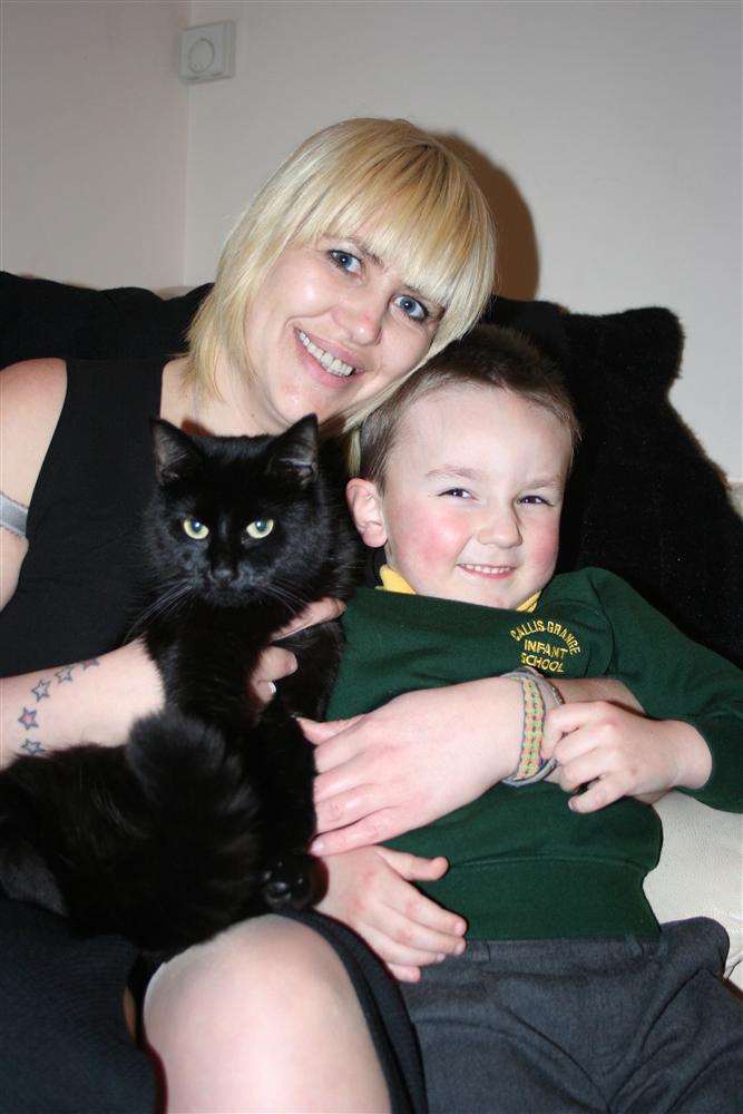 Black cat Dave gets a 'welcome home' hug from owner Coralie Relf and her nephew Coby-jay, five, after reappearing following publicity through the KM Group.