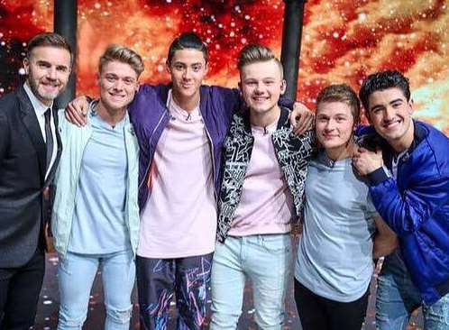 AJ Bentley stands next to Gary Barlow as Five to Five were crowned winners of BBC1's Let it Shine on Saturday. Picture: BBC