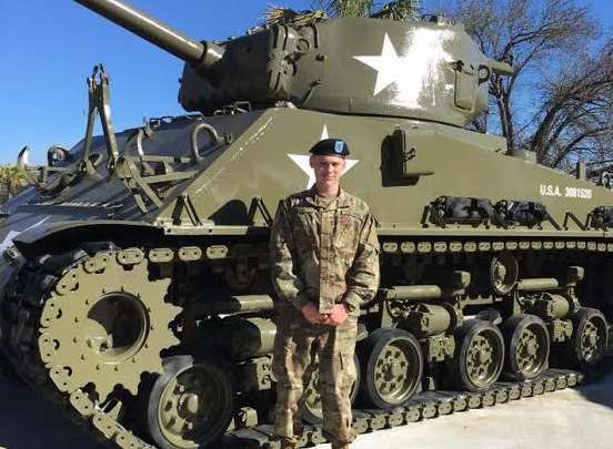 Ryan Todd in front of a tank