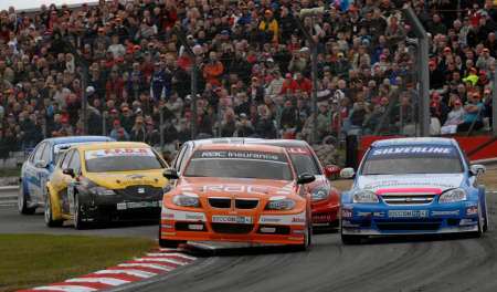 A full grandstand watches on as Colin Turkington (left) battles Jason Plato (right) in race three