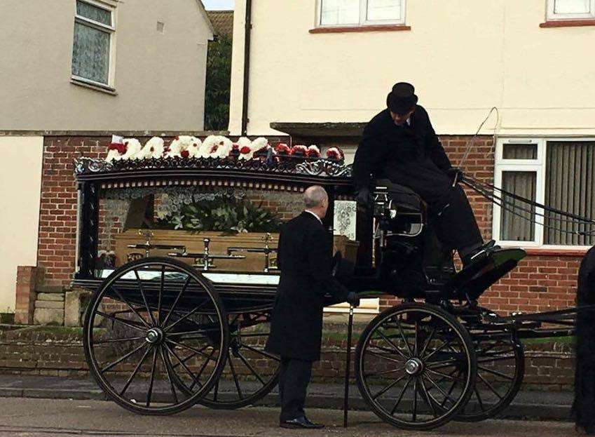 The hearse, bearing the 'Daddy' arrangement