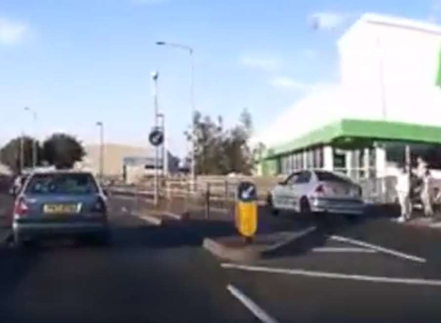 The car narrowly misses pedestrians as it veers across to the wrong side of the road