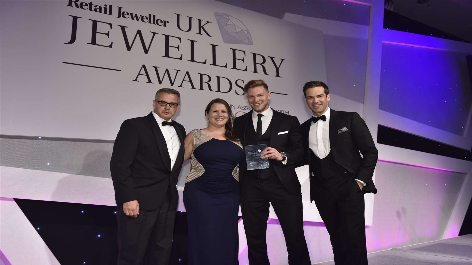 TV presenter Gethin Jones, right, presents Watchfinder's flagship store manager Robert Brooks, centre right, and deputy head of retail operations Ashlee Eastes, centre left, with their award
