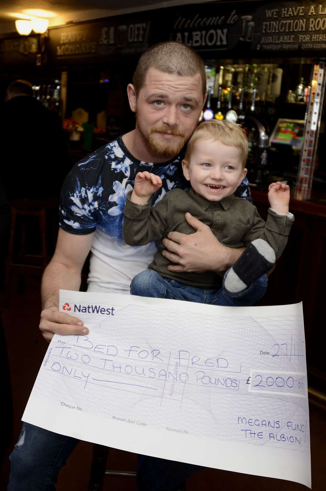 Freddie Lewis and dad Conor received the cheque from Albion pub regulars