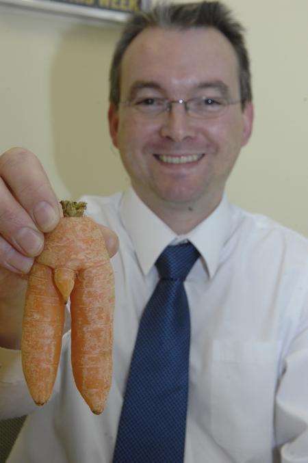 Mark Eastham with the suggestively-shaped carrot bought from Sainsbury's in Ashford