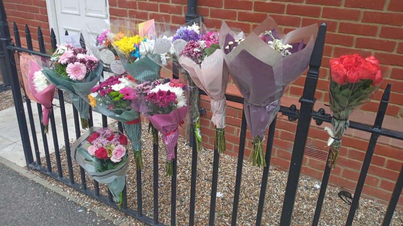 Flowers have been attached to a railing outside a home in Creine Mill Lane North, Canterbury, with heartfelt tributes to the woman