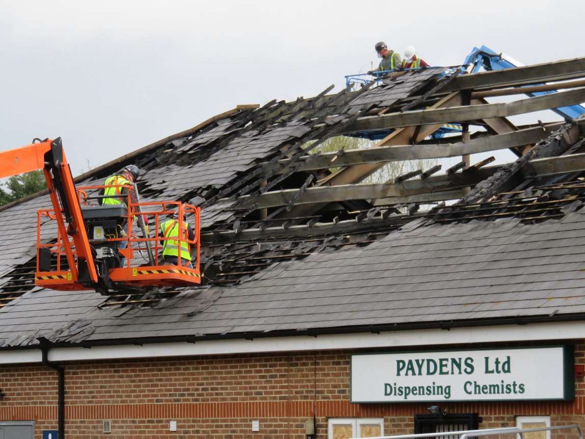 Workmen start removing the fire-damaged roof of the Tesco Express in Mace Lane, Ashford Picture courtesy: Andy Clark