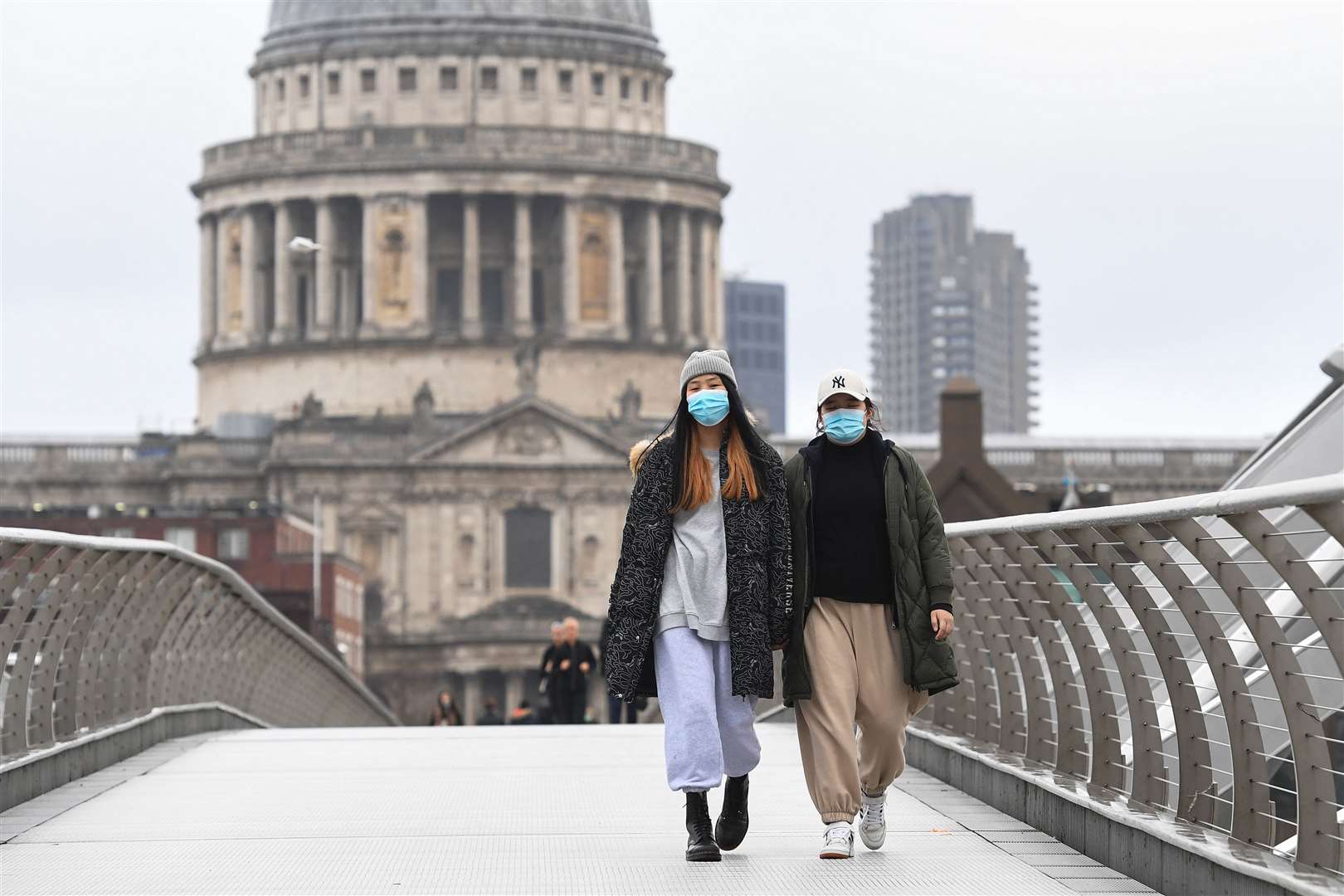 People walk in the rain over Millennium Bridge in London (Kirsty O’Connor/PA)