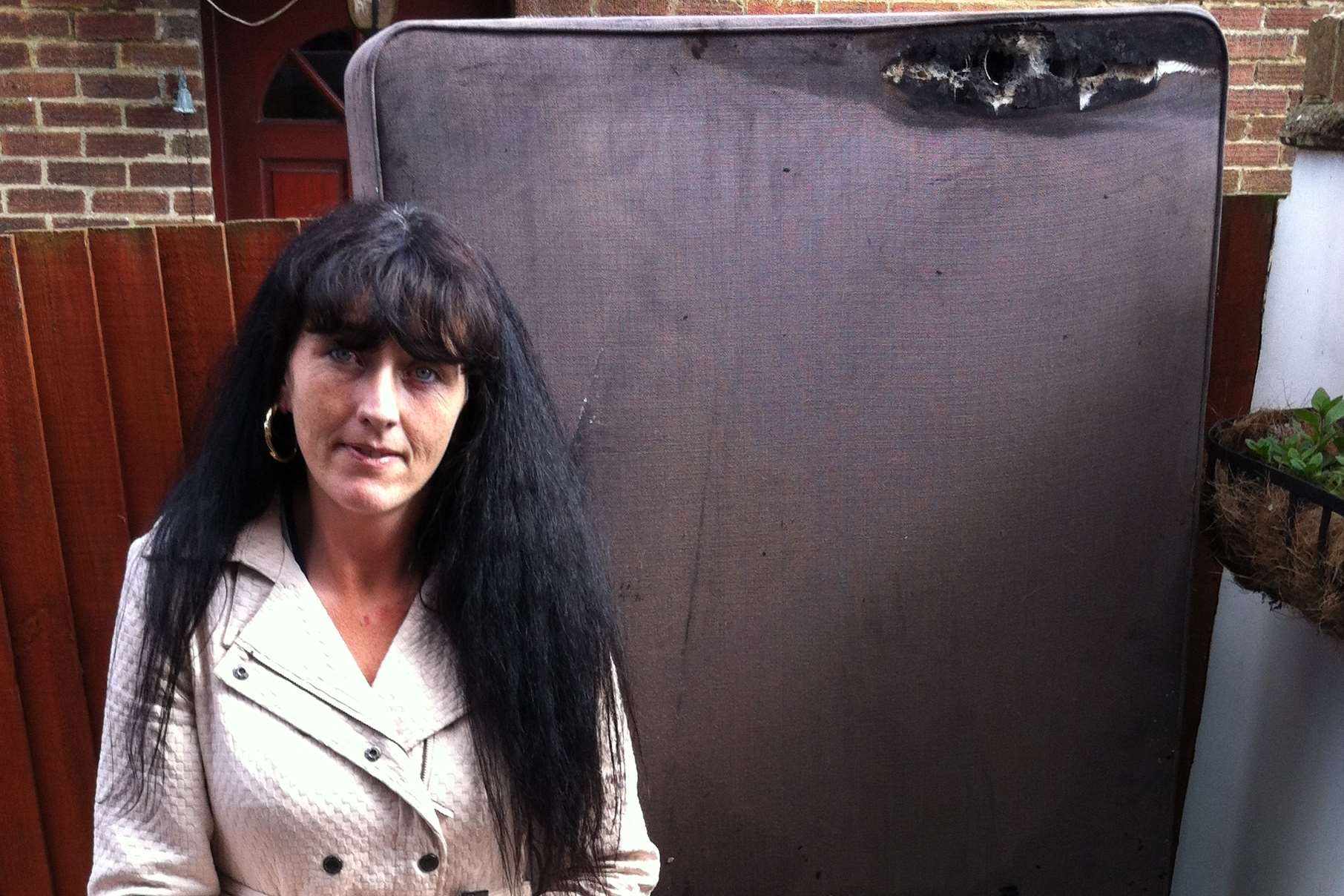 Mother Clare Butler with a fire-damaged mattress outside her Stockbury home