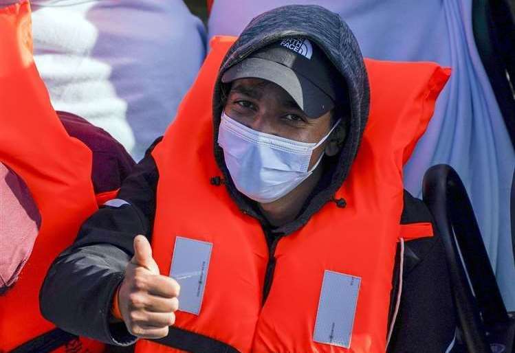 An asylum seeker puts his thumb up as he arrives in Dover Picture: Steve Parsons/PA
