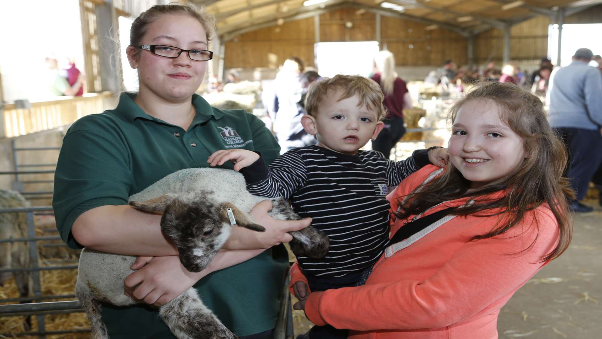 Student Taylor Bailey shows Thea Fisk, 12, and Nicholas, two, one of the new arrivals at Hadlow