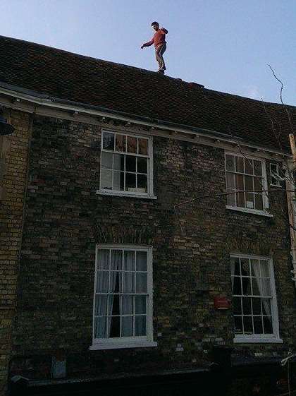 The man balancing on the roof of shops in Sun Street in Canterbury