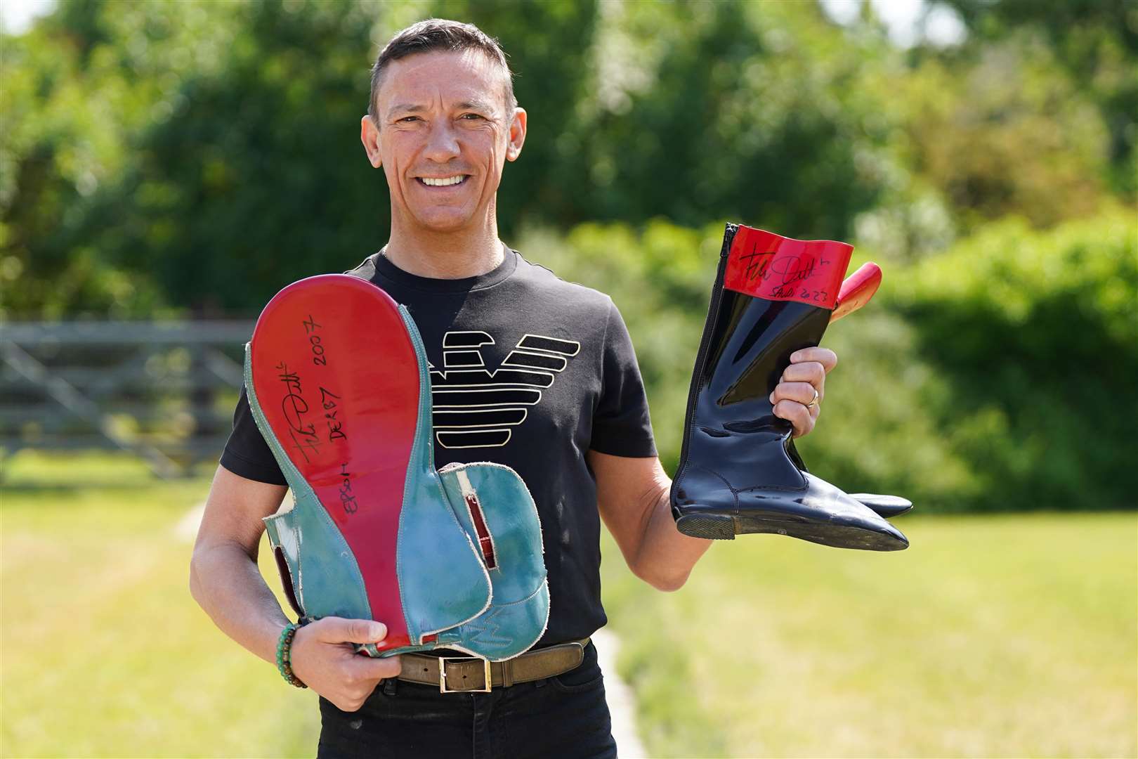 Frankie Dettori holds riding boots and equipment ahead of the auction (Jacob King/ PA)