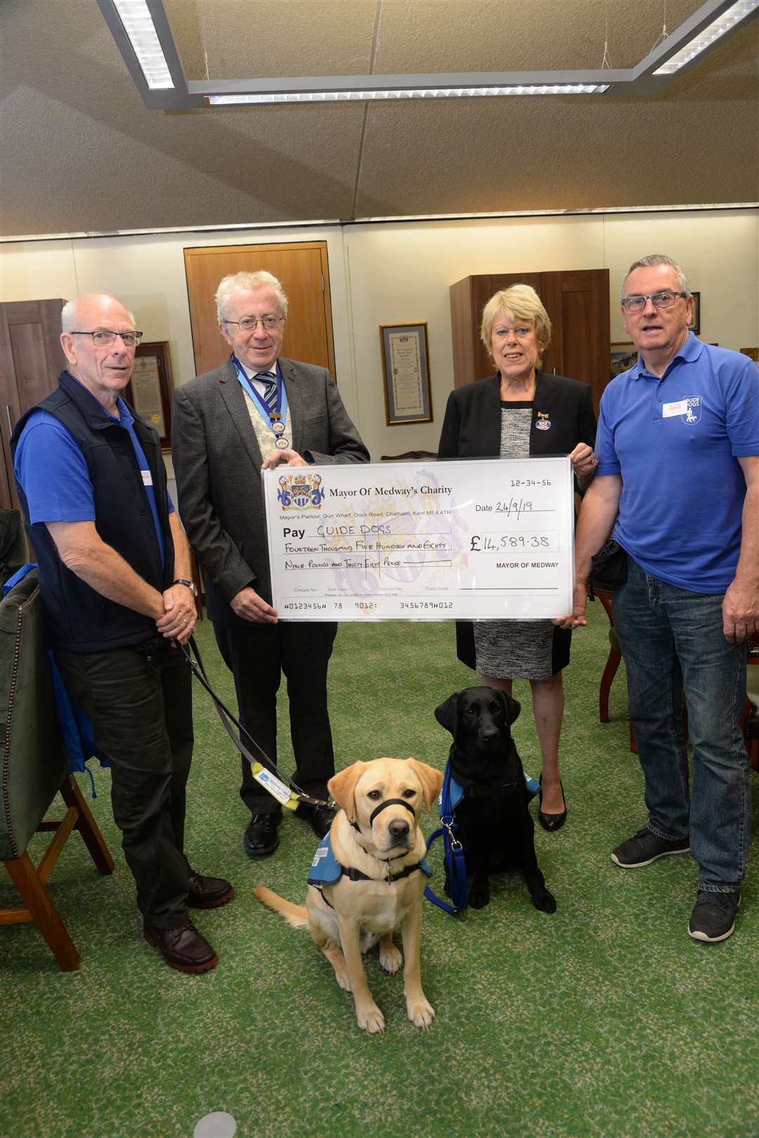 Puppy walkers Dan O'Donoghue with Simba and Brian Byers with Clodah and Steve and Josie Iles at a Guide Dogs for the Blind cheque presentation in 2019