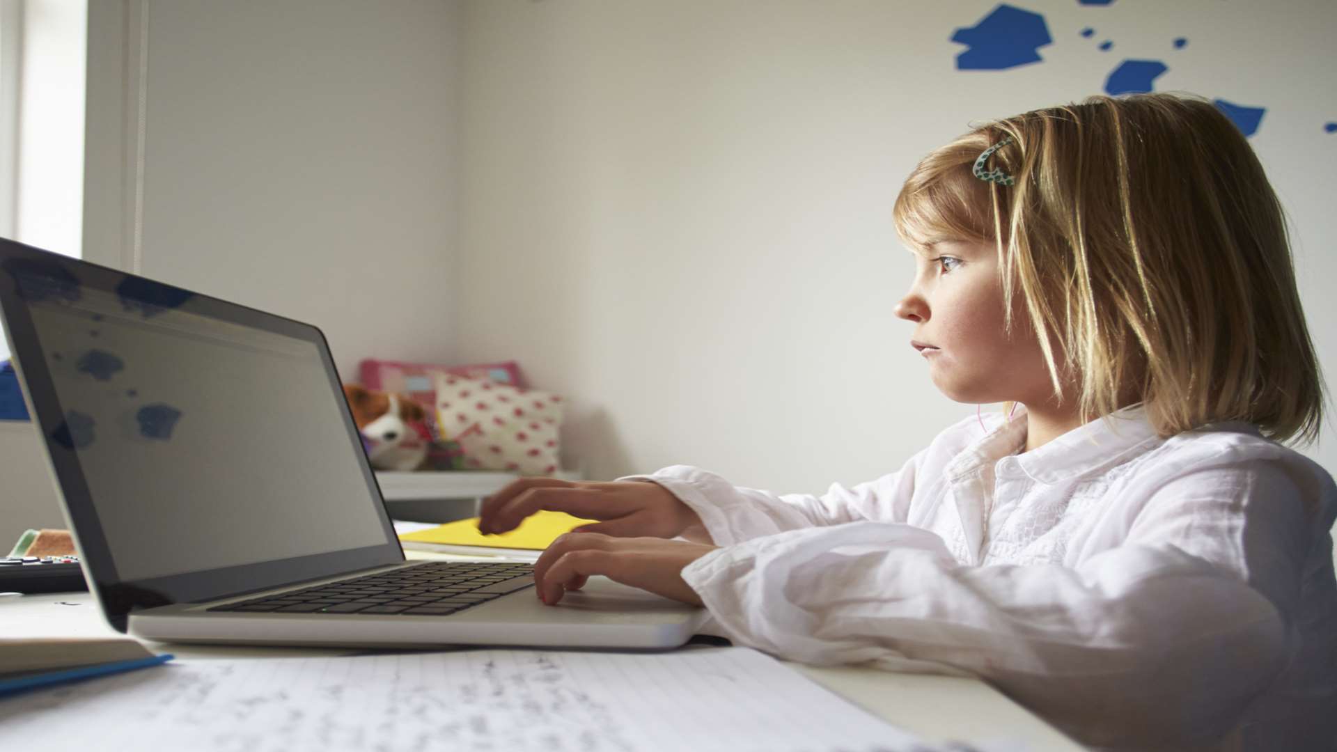 A girl using her laptop in her bedroom. Stock image