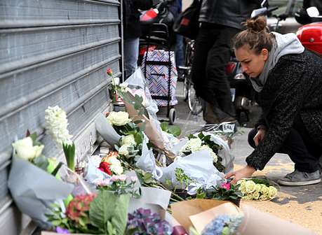 A woman lays flowers after the terror attacks in Paris last November